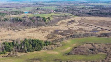 Doğanın üzerinde uçan bir hava videosu. Güzel ormanlar, tarlalar. Bulutlu gökyüzü.
