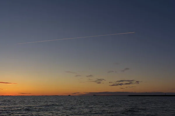 Прекрасний Помаранчевий Захід Сонця Морі Хімічною Стежкою Літака Над Небом — стокове фото