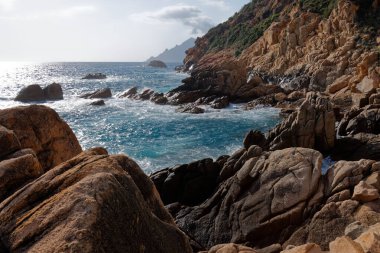 Denizin dalgaları Porto Körfezi 'ndeki kayalık kıyılarda yıkılıyor.