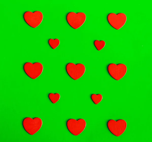 Yeşil zemin üzerinde kırmızı kalpler düz yatıyordu