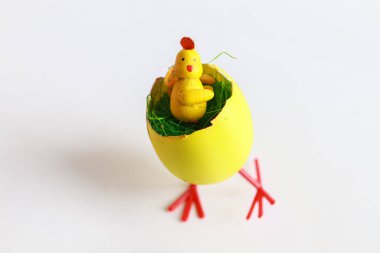 Oyuncak tavuk yumurta kabuğunda oturuyor, Paskalya dekoru.