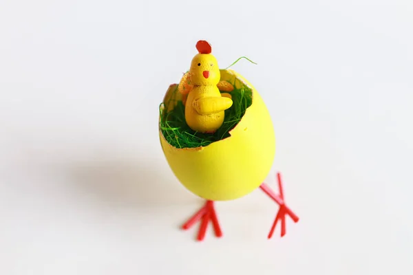 Oyuncak tavuk yumurta kabuğunda oturuyor, Paskalya dekoru.