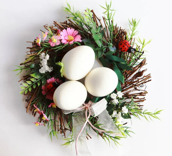 Beyaz arka planda Paskalya yumurtaları ve dekoratif çelenkler