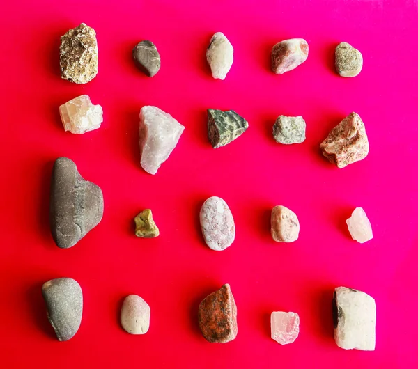 Kırmızı arkaplanda çok renkli değişken taşlar koleksiyonu