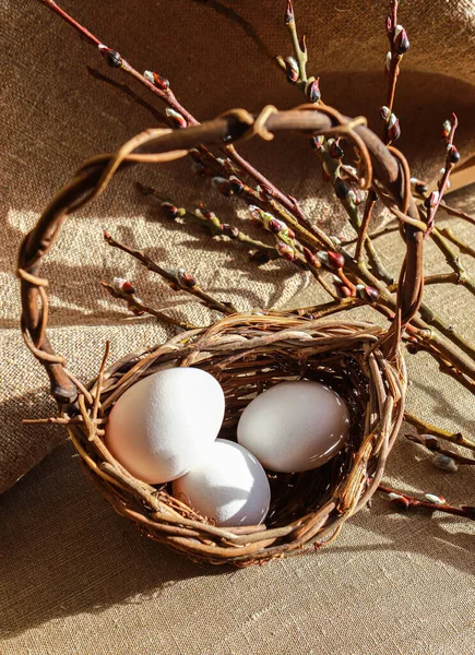 Easter unpaited white eggs in a basket with pussy willow