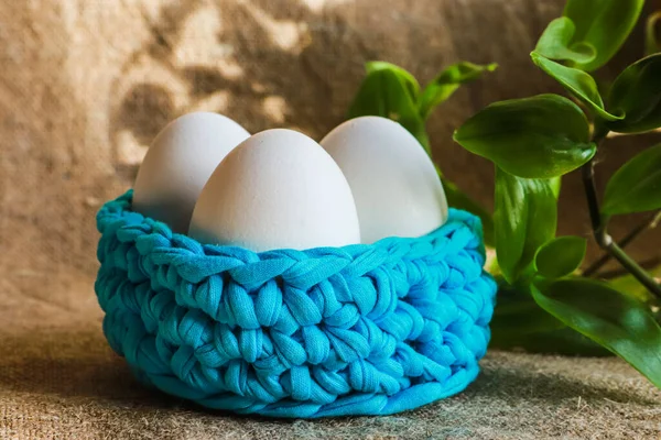 Easter unpaited white eggs in a basket with pussy willow