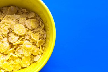 Sarı tatlı mısır gevrekleri mavi arka planda sarı tabakta