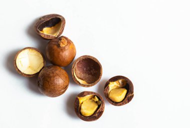 Kabuklu ve kabuksuz Macadamia fındıkları beyaz arka planda izole edilmiş. Düz yatıyordu