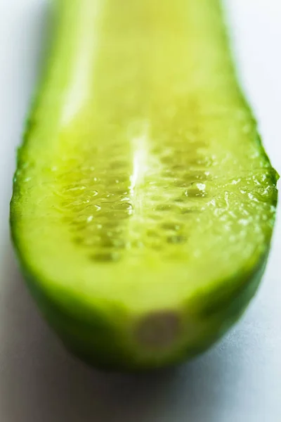 Beyaz arka planda su damlaları olan büyük doğranmış salatalık. Seçici odak