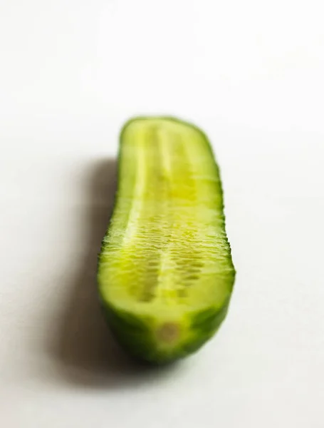 Big green chopped cucumber with water drops on white background. Selective focus