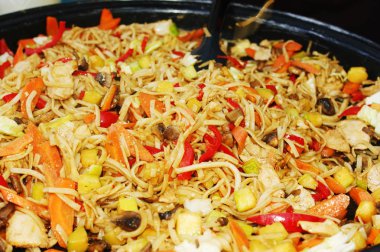 bir tavada kızarmış tavuk ve sebze ile erişte