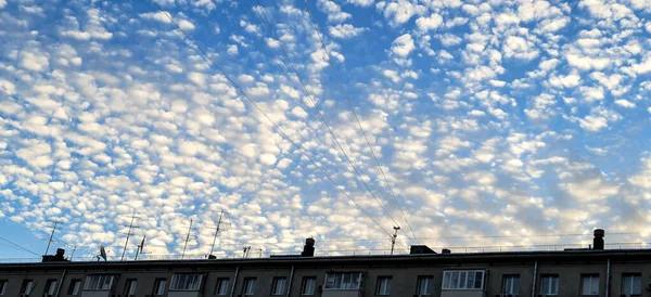 Nuvens brancas do nascer do sol sobre o telhado da casa residencial em Moscou — Fotografia de Stock