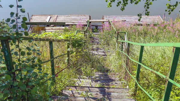 Escaleras metálicas viejas abandonadas al agua del río del país —  Fotos de Stock