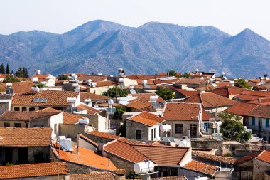 Dağ yamaçları ve güneşli Kıbrıs 'ın kırmızı çatı köyü 