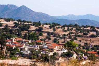 Dağ yamaçları ve güneşli Kıbrıs 'ın kırmızı çatı köyü 