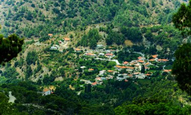 Dağ yamaçları ve güneşli Kıbrıs 'ın kırmızı çatı köyü 