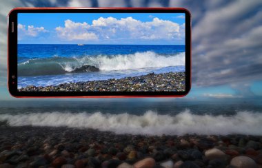 Karadeniz 'in Soçi bölgesinde ıslak taşlarla kaplı dalgalı deniz plajının karanlık gizemli arkaplanındaki cep telefonu ekranı kolajı