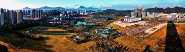 Shenzhen 'de güneşli bir günde konut binaları ve yüksek yollarla tipik Çin manzarasının geniş açılı panoramik manzarası