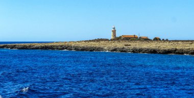 Kaya adası deniz feneri Yazın mavi Kıbrıs denizinde