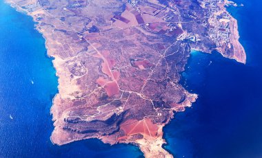 Kıbrıs adasının gökyüzü manzarası dalgalar, yatlar, şehir yardımı ve kıyı şeridiyle çevrili