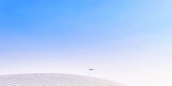 中国の深センの空港の球状コンクリート屋根の上に着陸する航空機の広い角度ビュー — ストック写真