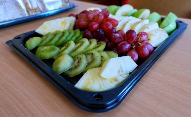 Tahta masadaki öğrencilere yemek servisi yapmak için canlı bir manzara.