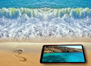 Mavi deniz kıyı şeridindeki ayak izinin kaleydoskopik deseni ve Kıbrıs yaz mevsiminde Kıbrıs 'ı gösteren cep telefonu