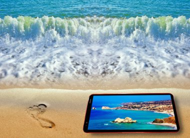 Mavi deniz kıyı şeridindeki ayak izinin kaleydoskopik deseni ve Kıbrıs yaz mevsiminde Kıbrıs 'ı gösteren cep telefonu