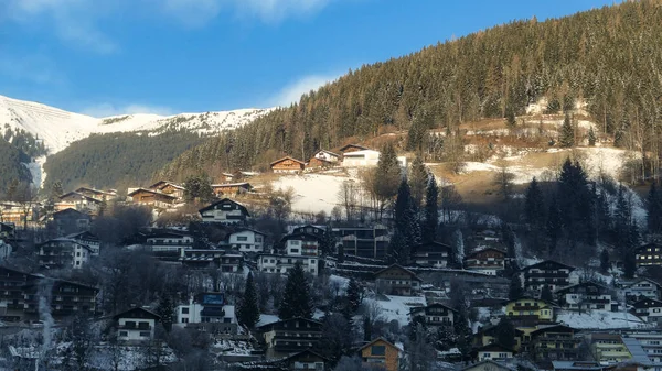 Winterskipiste Der Österreichischen Alpen Mit Sonnigen Dorfhäusern Schneebergen Und Immergrünem — Stockfoto