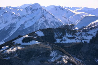 Avusturya 'nın kışın güneşli Alp zirveleri ve mavi sıradağlarının havadan görünüşü