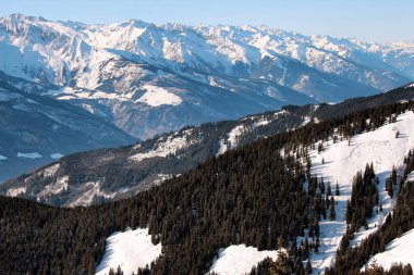 Avusturya 'nın kışın güneşli Alp zirveleri ve mavi sıradağlarının havadan görünüşü