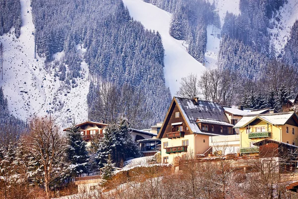 Sonniger Winterhang Der Alpen Mit Traditionellen Dorfhäusern Schnee Und Waldbäumen — Stockfoto