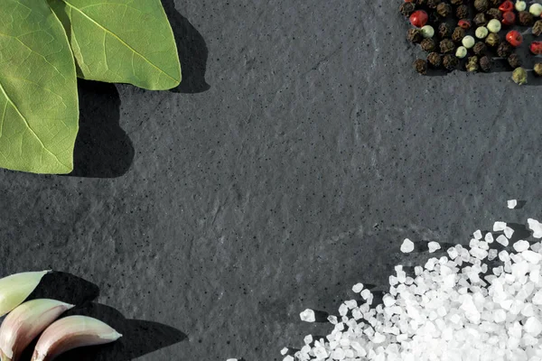 Sůl, pepř a bobkový listy na šedém pozadí — Stock fotografie