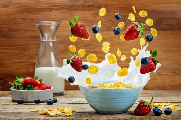 Healthy breakfast with milk, flying corn flakes, strawberries an