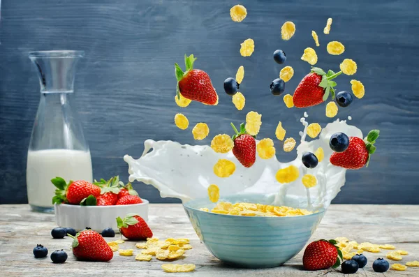 Healthy breakfast with milk, flying corn flakes, strawberries an