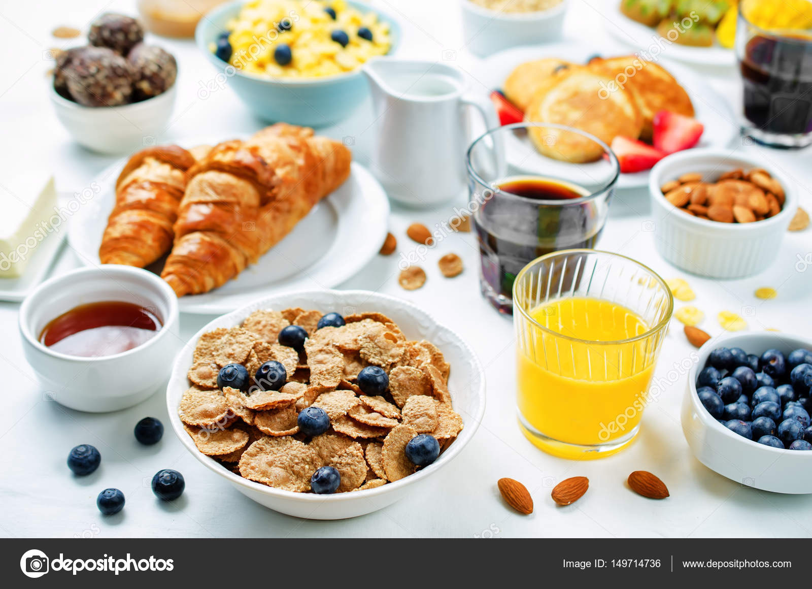Breakfast table setting with flakes, juice, croissants, pancakes ... Breakfast table setting with flakes, juice, croissants, pancakes ...