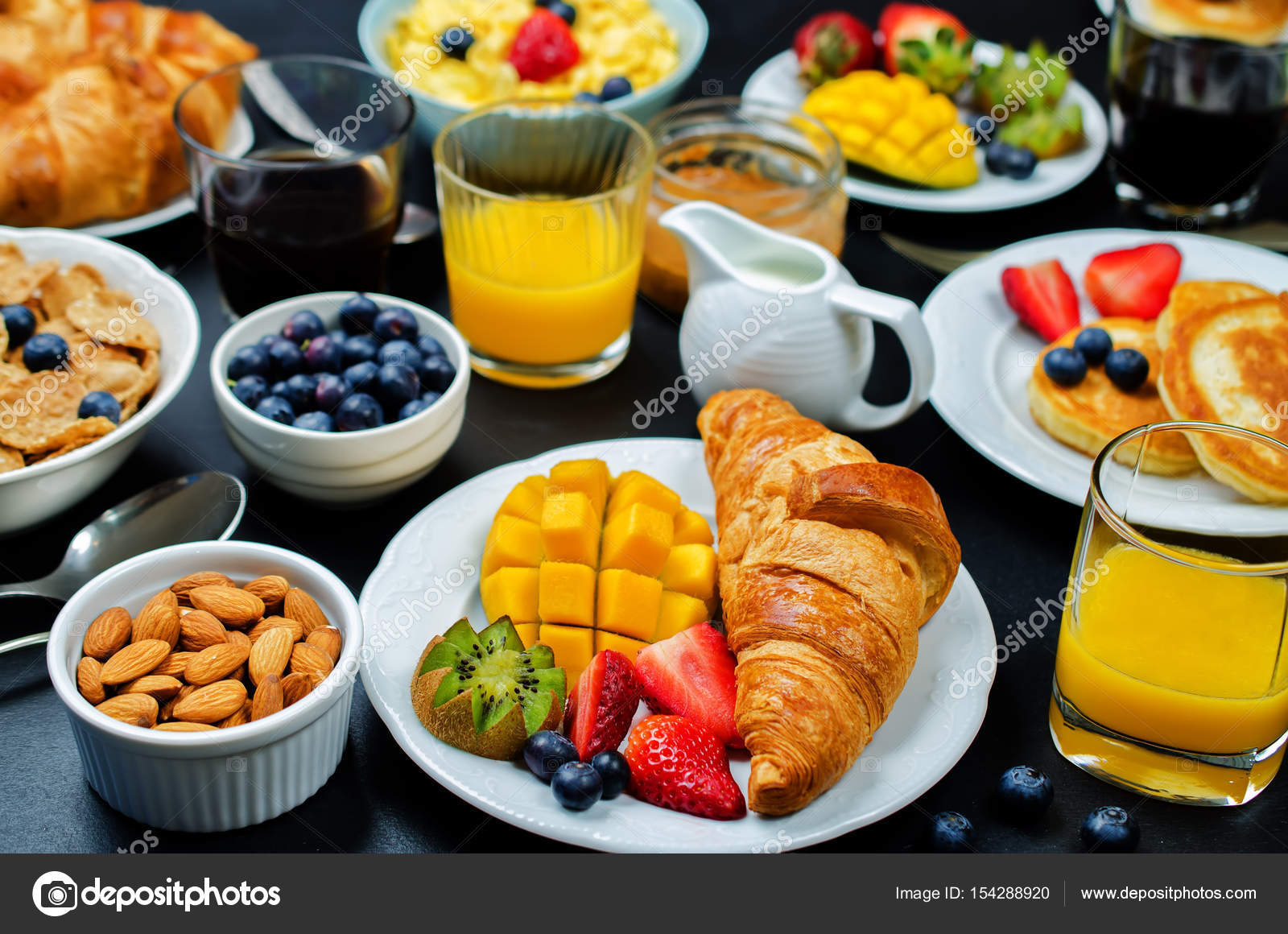 Breakfast table setting with flakes, juice, croissants, pancakes ... Breakfast table setting with flakes, juice, croissants, pancakes ...
