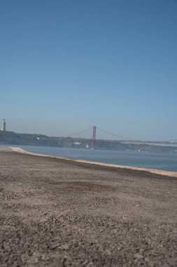 Lisbon 'daki sahil ve köprü manzarası. Portekiz 'de bir plajın fotoğrafı.