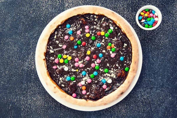Koyu arkaplanda çikolatalı pizza. Çikolatalı pizza resmi.
