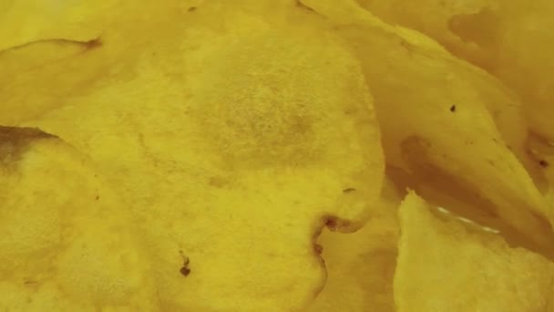 Yellow potato chips rotate in a plate — Stock Video