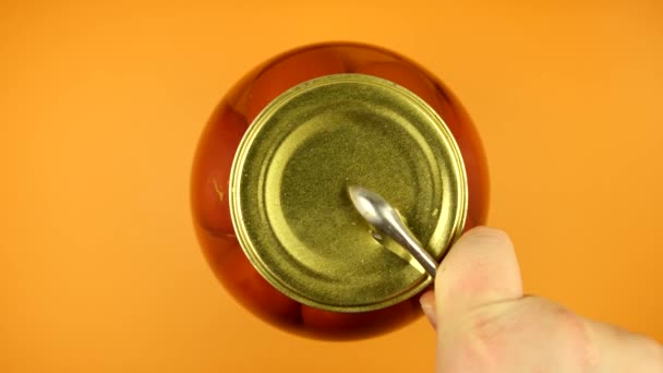 Sterke mannelijke handen openen een glazen potje tomaten met een blikopener, waardoor de bovenkant van het potje wordt afgesloten — Stockvideo