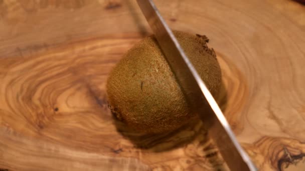 Koch Schneidet Kiwi Mit Scharfem Messer Auf Holzbrett — Stockvideo