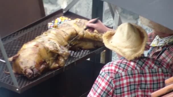 Gli uomini friggono il maialino su un fuoco aperto — Video Stock