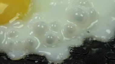Yumurta kızartma tavasında kızarır. Yukarıdan manzara. Yakın plan. Makro.