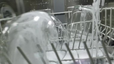 Ağır çekim. Bulaşık makinesinde bulaşık yıkama üzerine içeriden görüş