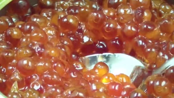 The jar of red caviar. rotates. Red caviar falls into the jar. — Stock Video