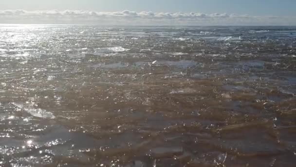 Olas con hielo en el mar en un día de primavera . — Vídeos de Stock