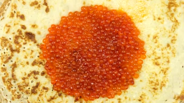 Der Pfannkuchen mit dem roten Kaviar dreht sich. Karneval. Der Blick von oben. Nahaufnahme. Makro. — Stockvideo