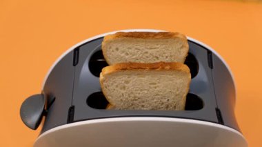 Tost makinesine iki parça beyaz ekmek koy ve çalıştır..