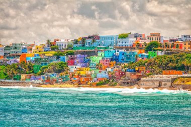 San Juan, Porto Riko 'daki plaja bakan tepe boyunca renkli evler var.